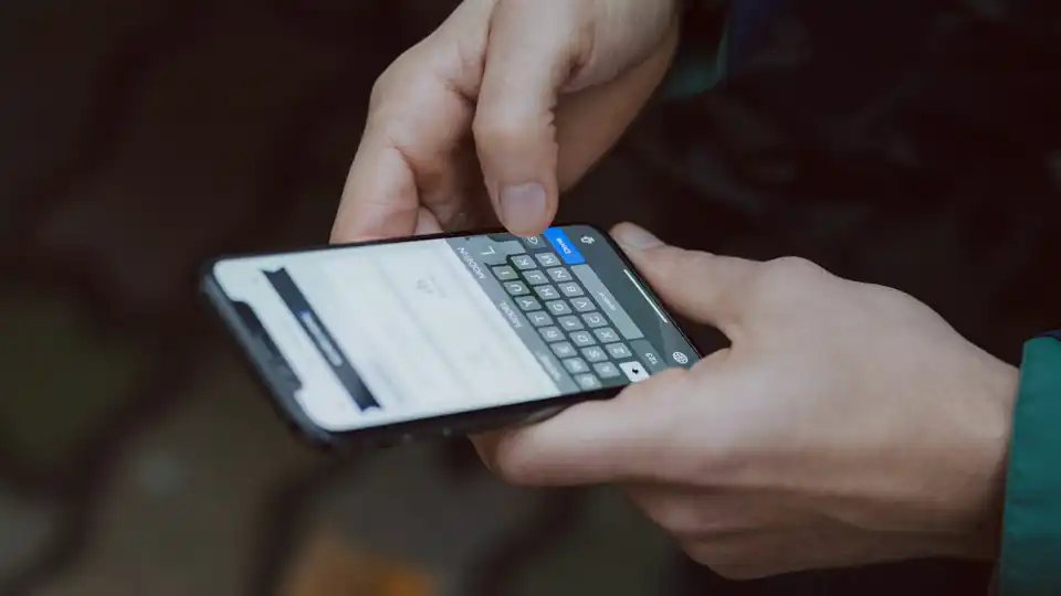 Pessoa usando um smartphone com foco nas mãos