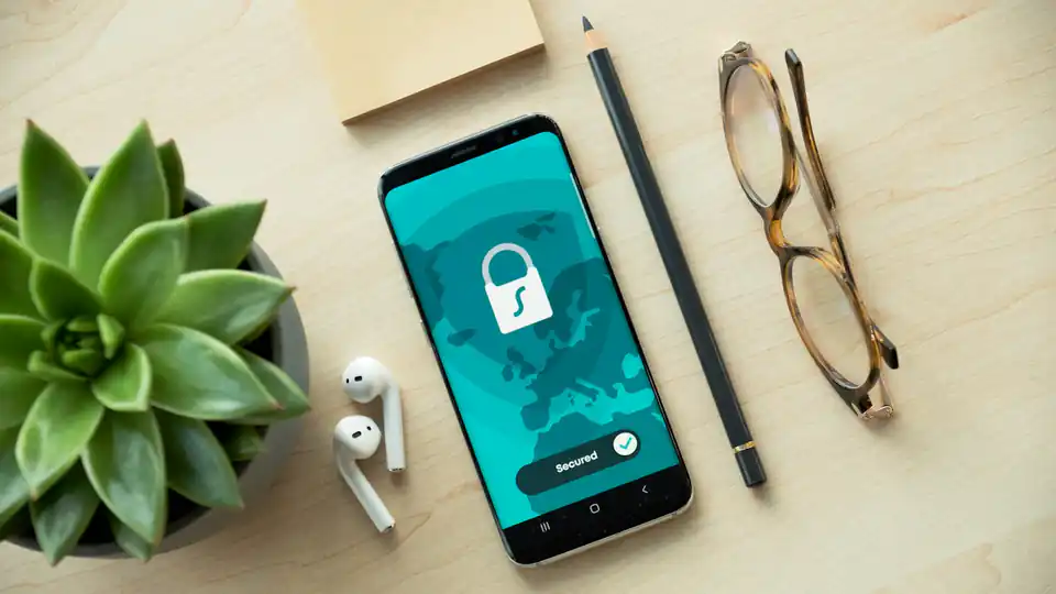 Smartphone com ícone de cadeado na tela sobre uma mesa de madeira